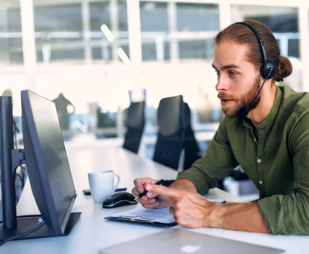 IT support technician providing remote support via computer and headset. IT-supporttekniker som ger fjärrsupport via dator och headset.