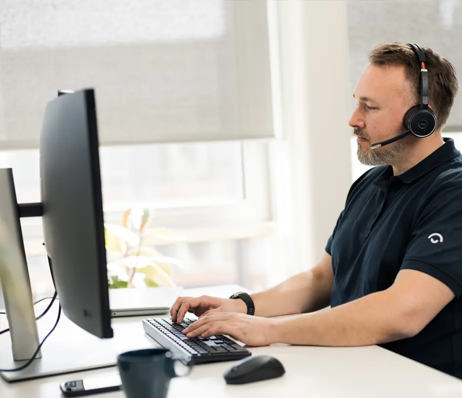 IT support technician providing remote support via computer and headset. IT-supporttekniker som ger fjärrsupport via dator och headset.