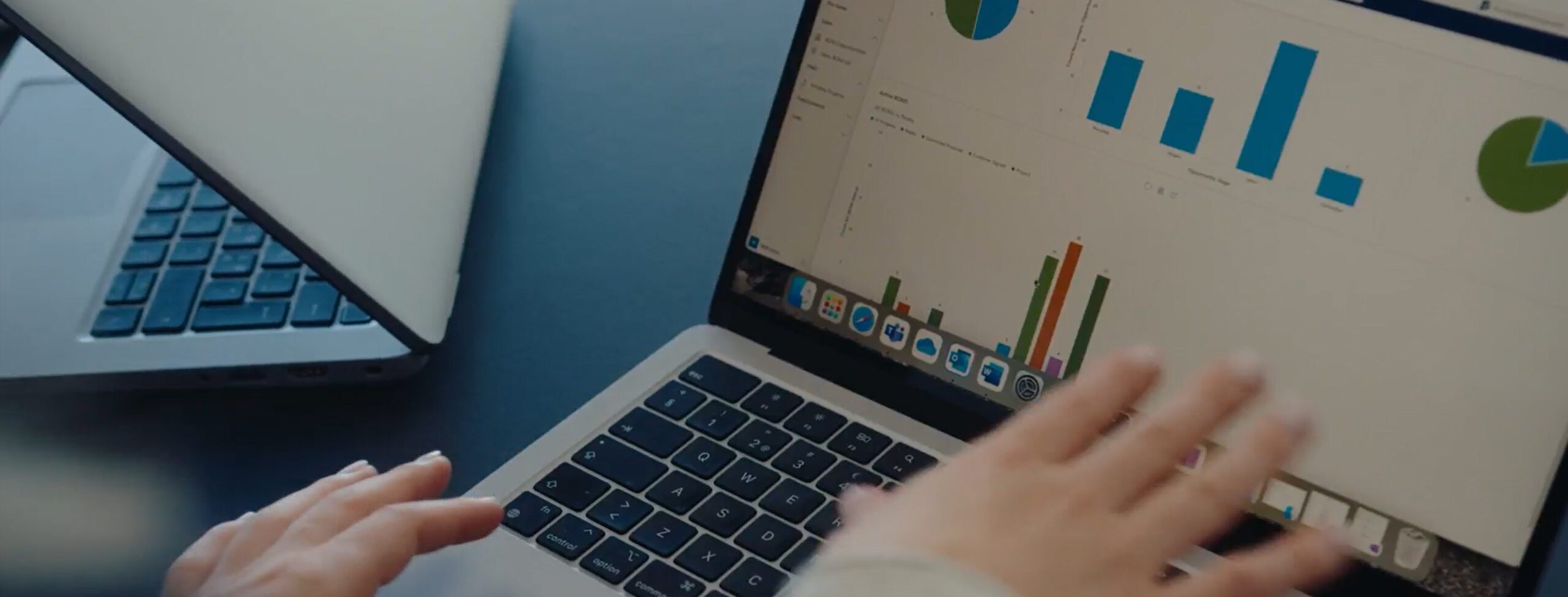 Person points at a laptop screen with charts