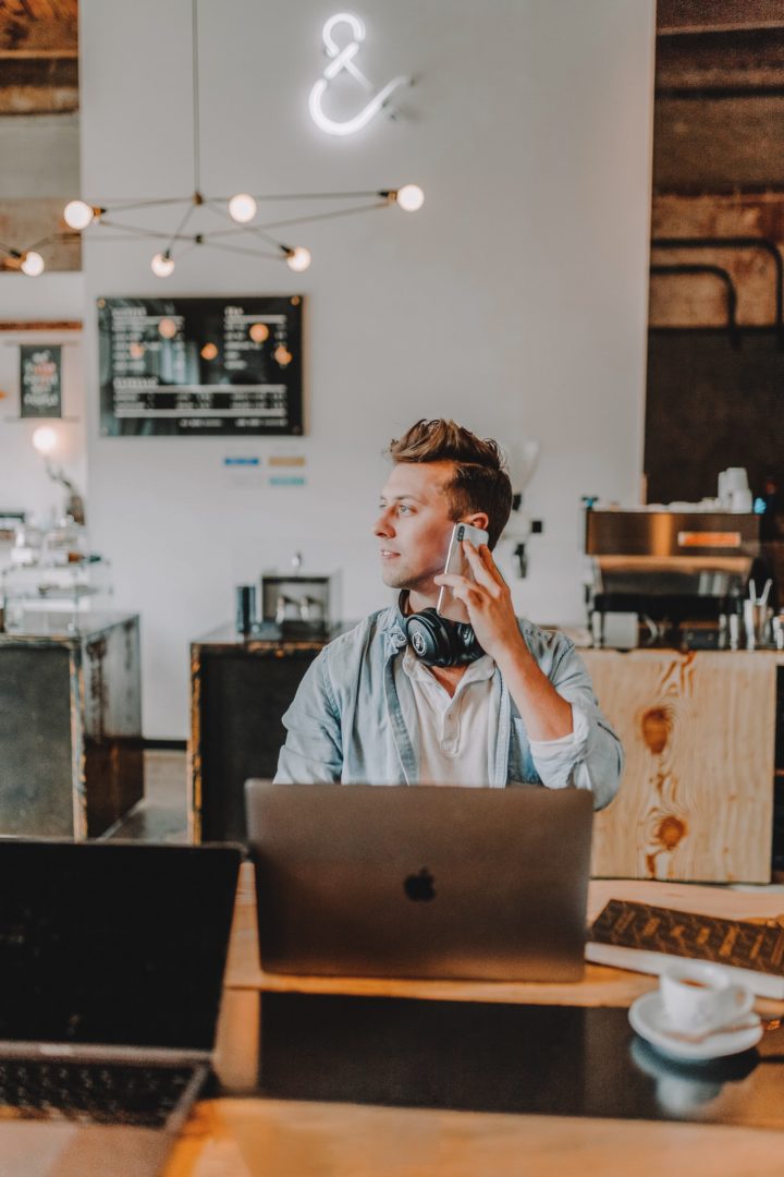 A man takes a call in a cafe that is today's hybrid office. En man tar ett samtal på ett cafe som är dagens hybrida kontor.