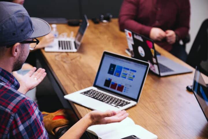 A man talking by a laptop in a meeting
