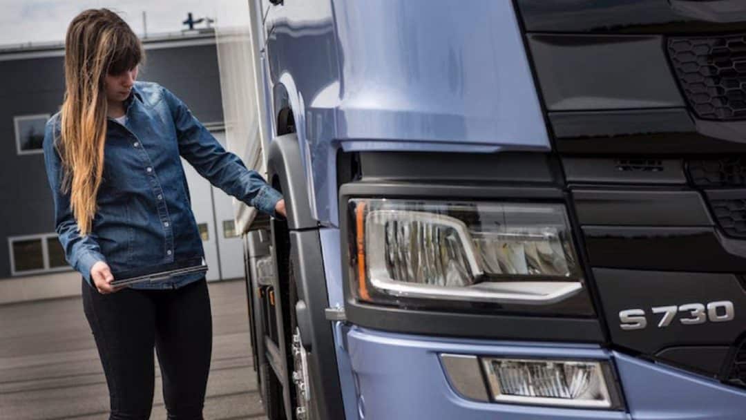 A person with an iPad is controlling a lorry.