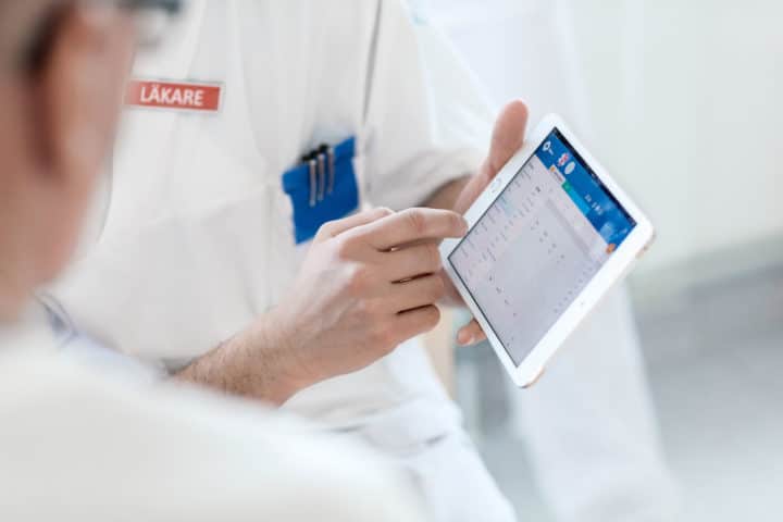 Two doctors discussing something on an iPad. Två läkare diskuterar något på en ipad.