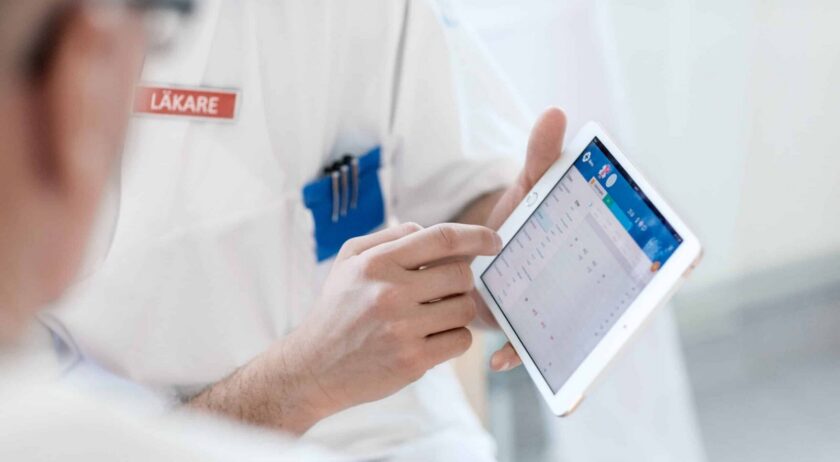 Två läkare som diskuterar något på en iPad.