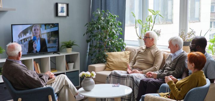 A group of pensioners watching television together at a nursing home