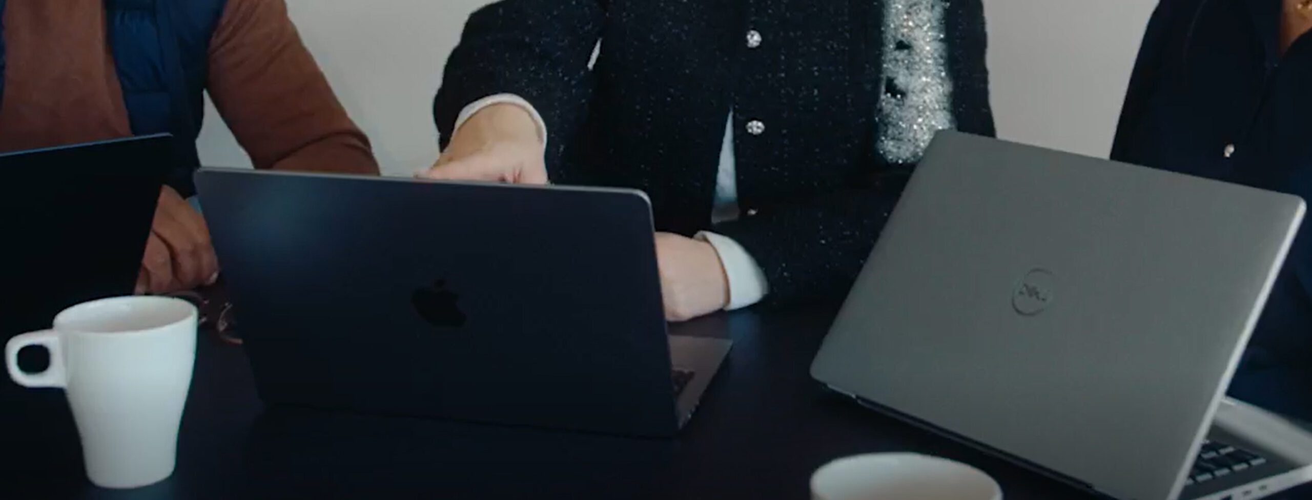 Close-up of three laptops that colleagues are working on