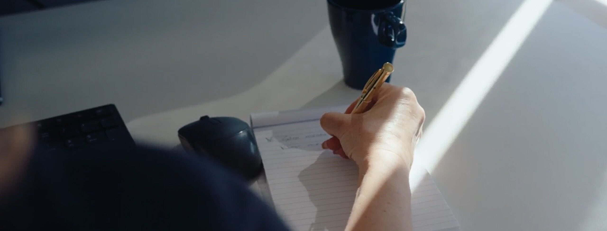 Hand notes in notebook with a gold pen