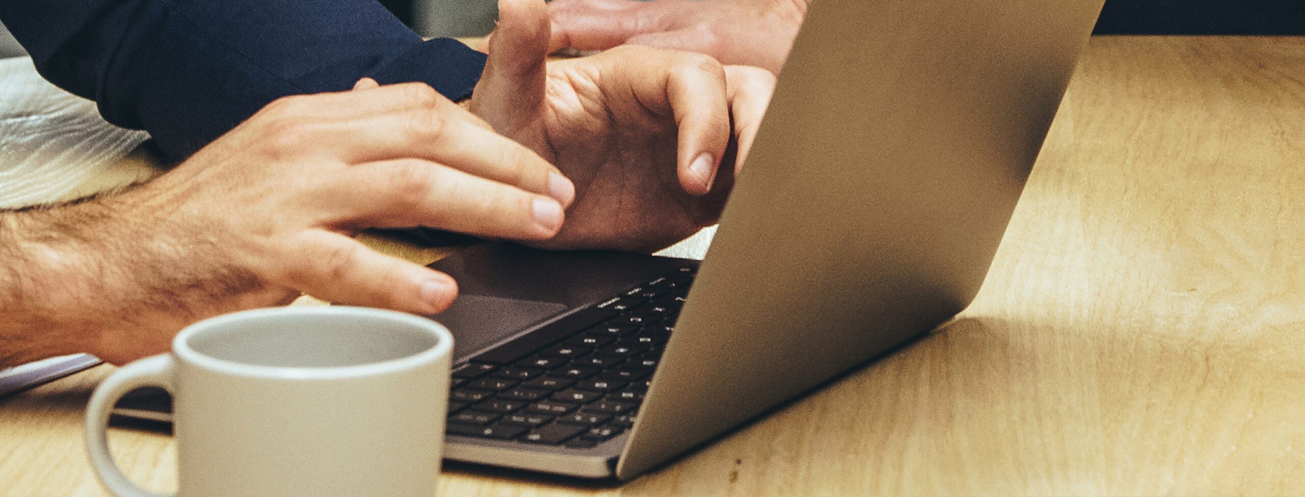 Hands working at a laptop