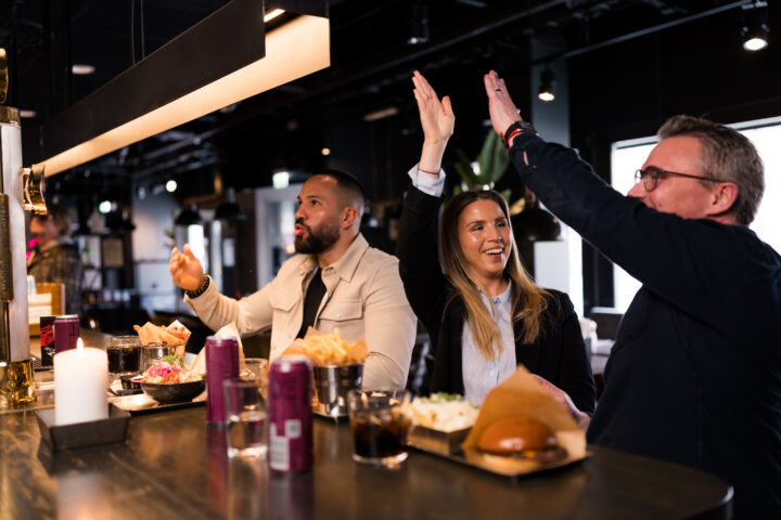 People eating food and high-fiving in a bar
