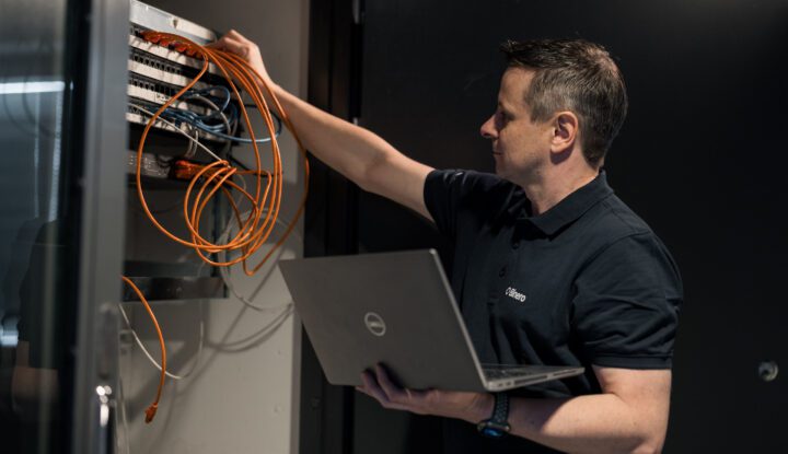An installer with a laptop reconnects cables