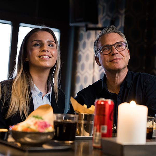 Watching TV and eating food in a bar