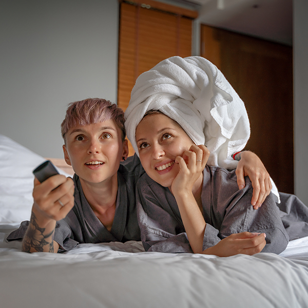A couple watching TV in a hotel bed