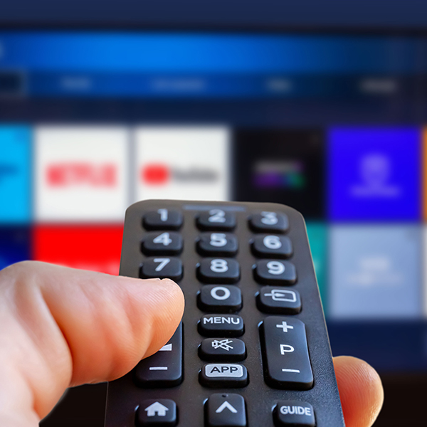 Remote control pointed at a TV with channel selection
