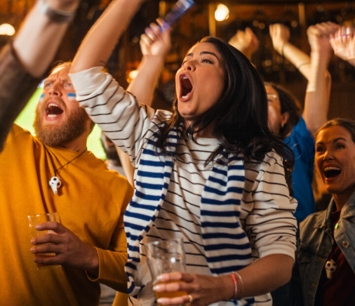 Happy football fans cheer and shout