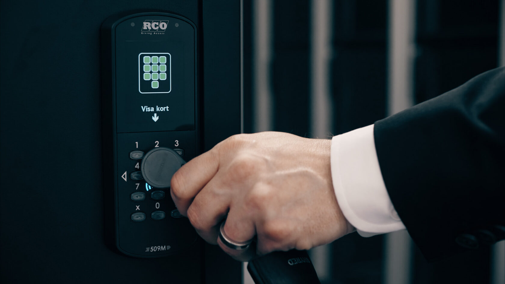 En hand håller ett plastkort mot en digital kortläsare med texten "Visa kort" på displayen.